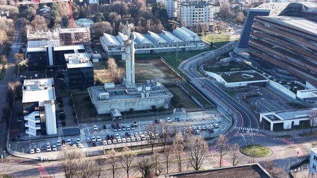 Urban Landscape: A high-angle shot captures a dynamic city scene, showcasing an ensemble of modern buildings, a distinctive tower, and the graceful flow of roads, all under a clear blue sky.