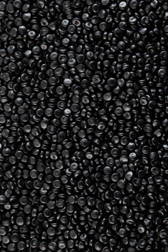 Texture of Black PE pellets, close-up. Black coloured polyethylene granules. Masterbatch, Virgin polymer. Granulated plastic compound