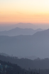 Obraz premium misty mountain landscape at dawn with orange sky and layered hills