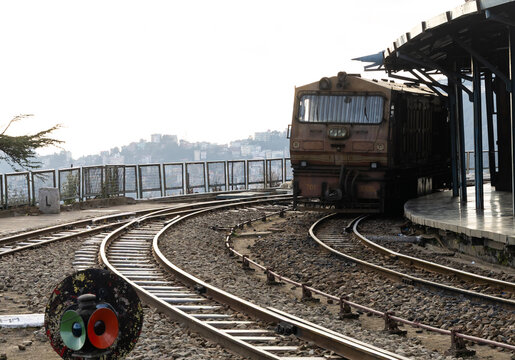 vintage mountain train waiting on curved hill station tracks at evening