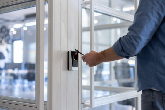 Person scanning key card on a sleek access control reader to unlock an office door, illustrating modern digital security, authorized entry, and everyday corporate access procedures