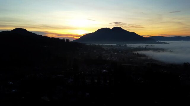 Golden sunrise over misty mountains in the Berastagi highlands of North Sumatra