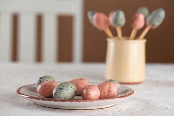Homemade marzipan Easter eggs on a plate and sticks. Vegan candy. Sugar, gluten and lactose free.
