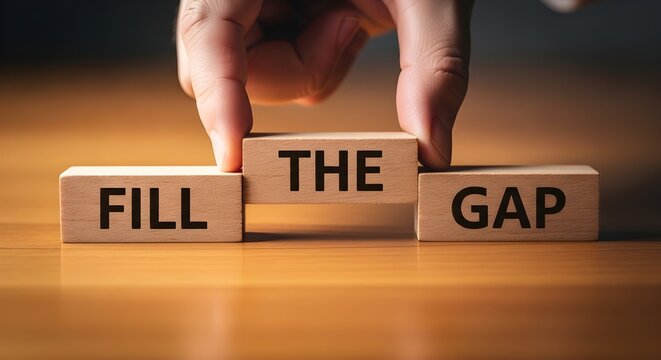Hands placing wooden blocks with the words fill the gap together symbolizing solving business challenges or bridging divides