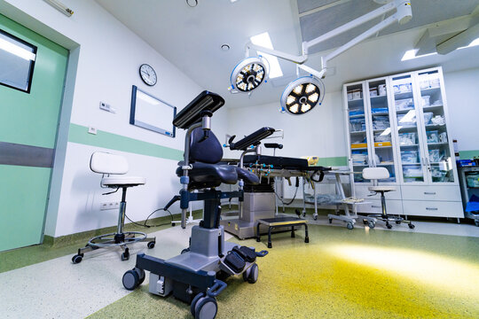 High tech surgical room with medical equipment and cabinets. Interior of modern operating theater with overhead LED lamps, surgical table, and storage furniture.