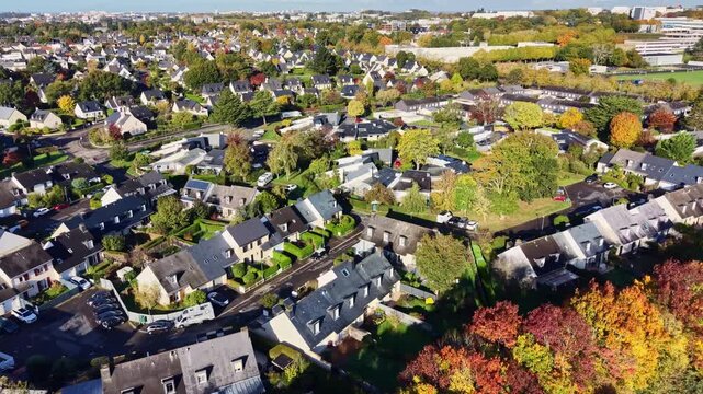Suburban houses with colorful autumn foliage on the trees in Cesson-S&eacute;vign&eacute;, France. Aerial drone forward