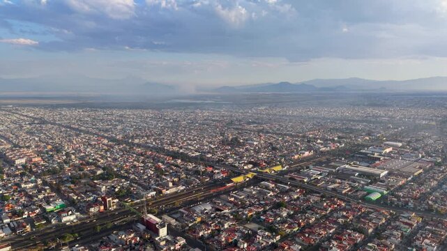 Drone view of Ecatepec with haze and fires seen on the skyline
