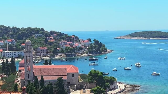 The island of Hvar in Croatia on the Adriatic Sea. Boats drive and dock on the gorgeous blue water surrounding the island and the numerous beaches and villas.