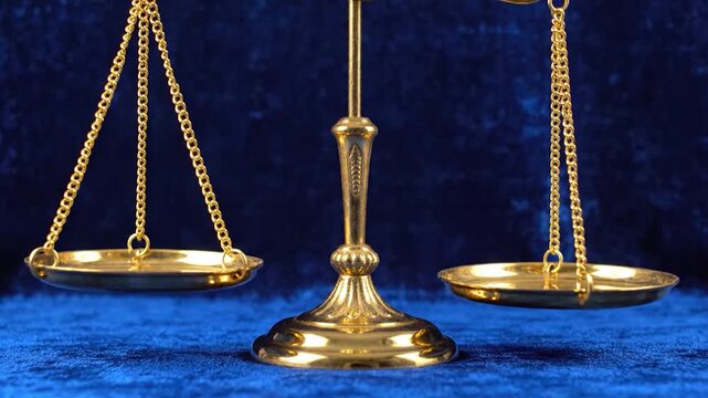 A shiny golden balance scale stands against a deep blue background, symbolizing