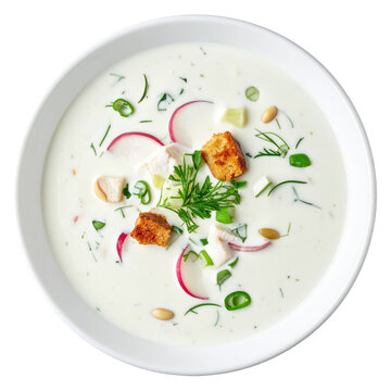 Refreshing chalap, a cold yogurt and herb soup, being poured into a bowl and isolated on a stark white background