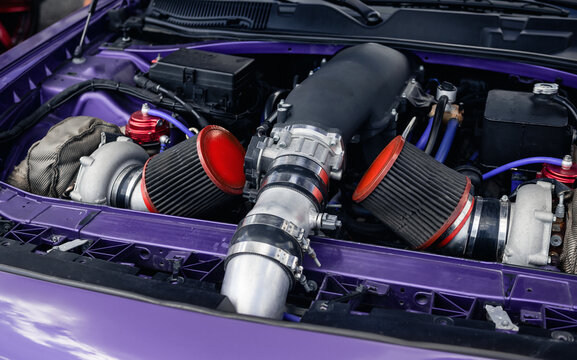 Close-up of supercharged engine in purple car. American car with powerful v8 engine that has forced induction - supercharged bolted to it on top.