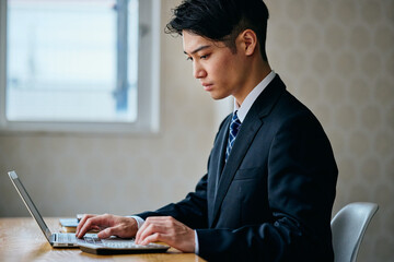 Businessman Typing on Laptop at Office Desk