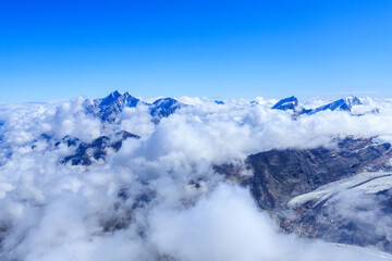 Fototapeta premium Panorama with mountain summits Dom, Alphubel, Rimpfischhorn and Strahlhorn (left to right) over cloudscape in summer in Swiss Alps, canton of Valais, Switzerland
