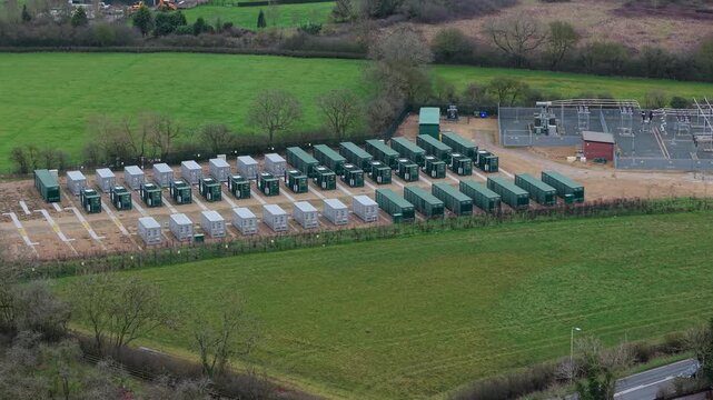 Drone Shot Of Modular Battery Storage Units And Inverter Skids For Renewable Energy Balancing In Enderby