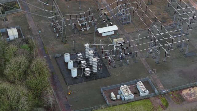 Close-up aerial view of 400kV power transformers and high-voltage switchgear at Enderby electrical substation UK, illustrating grid stability.