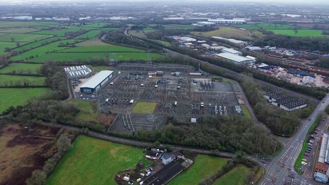 Aerial drone view of a massive electrical substation in Enderby, UK, featuring complex busbar networks and high voltage transmission pylons.