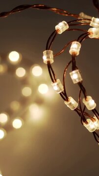 Vertical video: Opening microLED lights glowing on twisted copper wires decorating wall, copy space