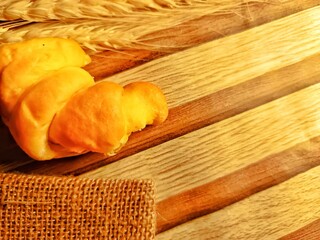Fresh Bread with Wheat on Wooden Background