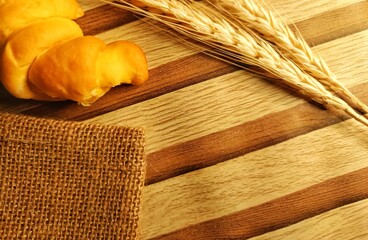 Fresh Bread with Wheat on Wooden Background