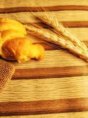 Fresh Bread with Wheat on Wooden Background