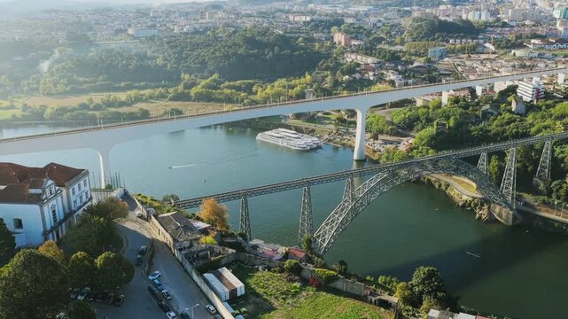Drone aerial view of Dom Lu&iacute;s I Bridge, Porto, Portugal on 07 February 2026. Iconic double-deck iron arch spans Douro River, historic districts, riverside buildings, and urban landscape from above.