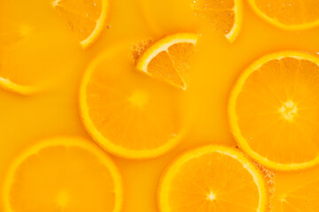 Abstract background of orange slices covered with juice.