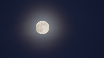 Photography of Moon in the full moon lunar phase in the foggy sky. © volff