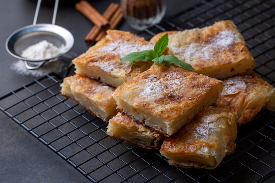 Greek pie called Bougatsa with cheese slightly blurred cross section and selective focus on powdered sugar and cinnamon
