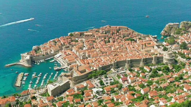 Drone aerial view of Dubrovnik Old Town, Croatia on 06 June 2025. Medieval stone walls, red tiled rooftops and Adriatic coastline under bright Mediterranean summer light.