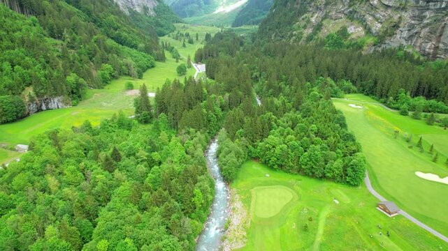 Drone aerial view of Engelberg, Switzerland on 27 September 2025. Alpine peaks, rolling green meadows and traditional chalets surrounding mountain village in clear natural daylight.
