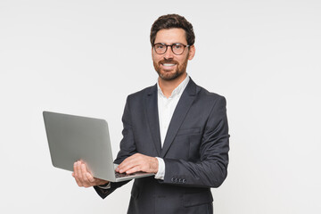 Busy business man using laptop standing isolated on white background. Male professional businessman...