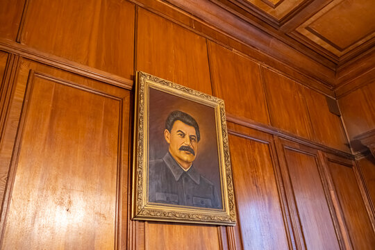 A painting depicting Stalin. The painting hangs in Stalin's summer residence in Sochi. A wall of wooden panels on which hangs a portrait of Stalin. The cult of personality.
