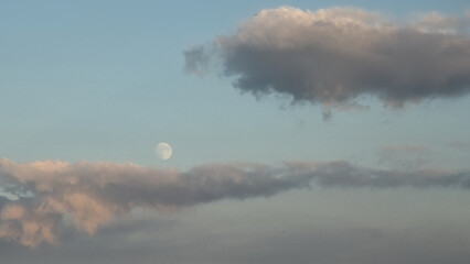 Colourfull evening sky with almost full moon and clouds. © Kristof Lauwers