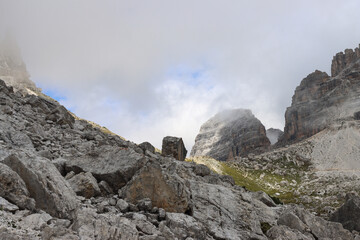 Fototapeta premium Cloud‑covered Dolomites peaks rising above Rifugio Lavaredo in dramatic alpine scenery