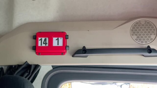Interior shot of a red vehicle height indicator sign inside a truck cab showing fourteen feet and one inch