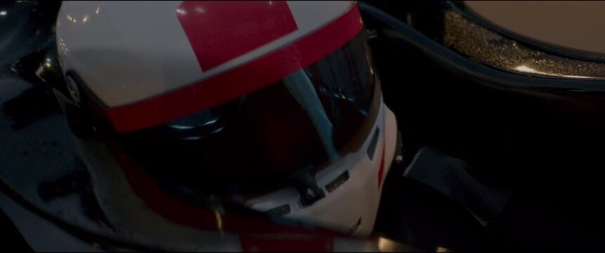 Close-up of a race car driver in a driving fast on a racing track, evening race