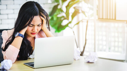 Young Asian woman stress with her frustrated or unsuccessful business online shopping at office. Boring or unhappy business office life concept.