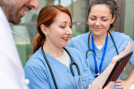 Healthcare workers collaborating and using a tablet to enhance teamwork and communication in a modern clinical setting