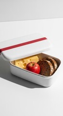 Minimalist rectangular container holds fresh lunch components on bright white surface