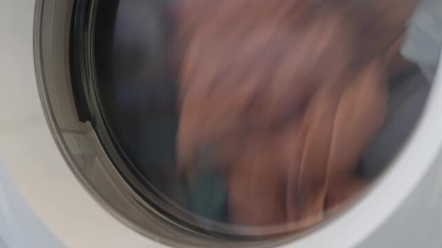 Clothes dryer machine tumbling laundry creating a rhythmic thumping and continuous motor hum sound