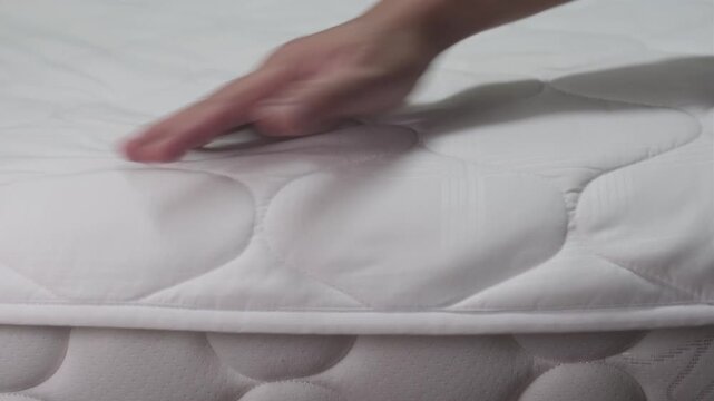 Hand firmly slapping and sweeping a fabric bed sheet to remove dust creating a loud thumping and rustling sound