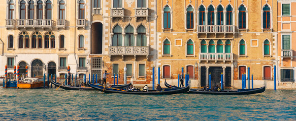 Lively Venice canal scene with gondolas, gondoliers and tourists along colorful historic buildings. Traditional Venetian architecture and emerald water create vibrant travel atmosphere