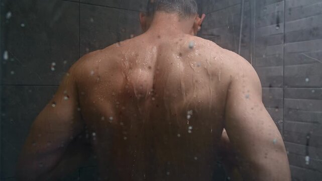 Medium shot. A middle-aged Caucasian man showering at home. Cleansing the skin, showering, and hygiene are essential for health, well-being, and hygiene in the bathroom
