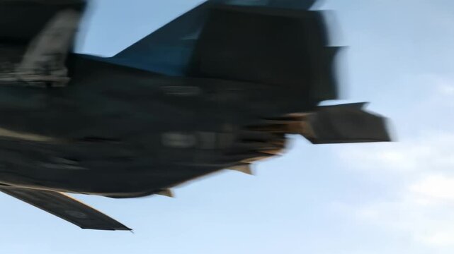 A female pilot in the cockpit of a modern fighter jet confidently operates the aircraft while flying over snowy mountain peaks