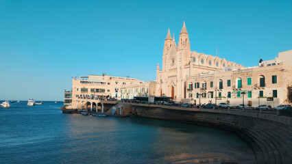 Obraz premium A public beach at the St Julian’s Bay(San Giljan) and Urban Waterfront, Malta on sunny day