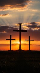 Three crosses silhouette on a hill at sunset. Religious concept for Easter holiday and christianity. Dramatic sky with sun rays shining.