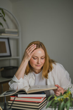 Businesswoman reading a book during coffee break at workspace