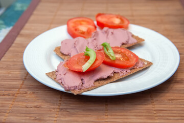Sandwiches with Liver Pate, Tomatoes and Rye Crackers on White Plate. Selective Focus.