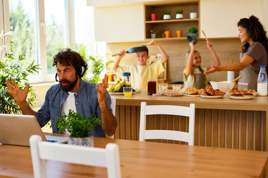 Working from home interrupted by noisy family in kitchen