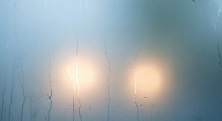 Misty Window with Illuminated Lights in the Distance 